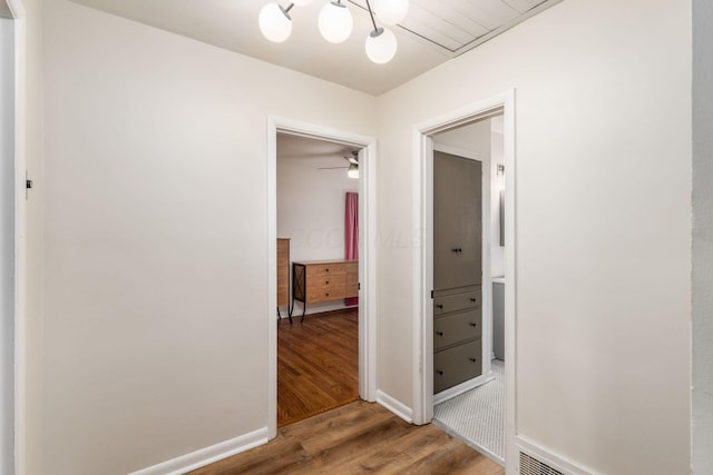hallway featuring wood finished floors and baseboards