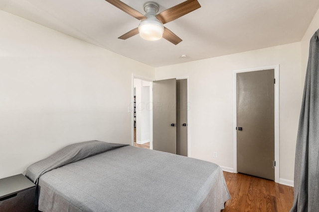 bedroom featuring wood finished floors, baseboards, and ceiling fan