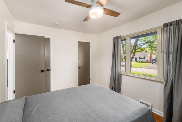 bedroom with baseboards, wood finished floors, and ceiling fan