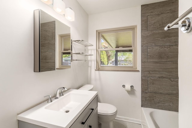 bathroom featuring toilet, vanity, and baseboards
