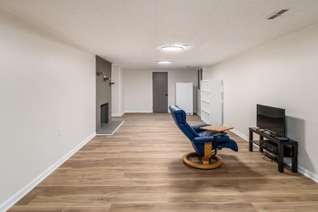 unfurnished living room featuring a fireplace, baseboards, and wood finished floors