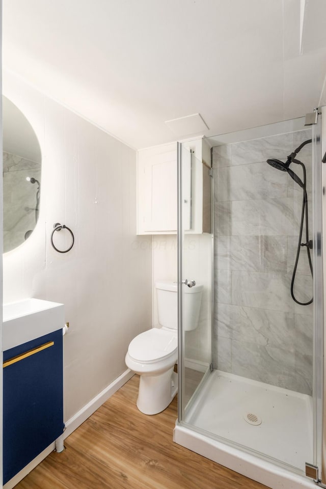 full bathroom with a shower stall, vanity, toilet, and wood finished floors