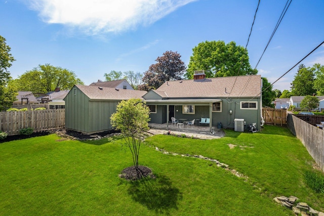 back of house with a patio area, central AC unit, and a chimney