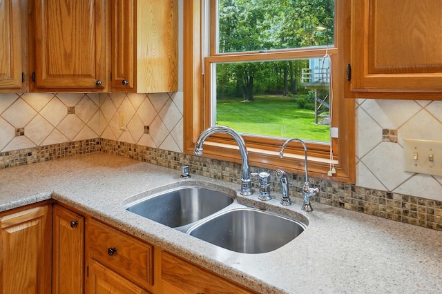 7227 Stemen Rd, Pickerington, OH 43147 - kitchen with a sink, tasteful backsplash, light stone counters, and brown cabinets