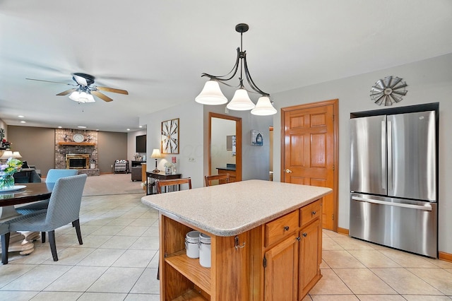 7227 Stemen Rd, Pickerington, OH 43147 - kitchen featuring freestanding refrigerator, light tile patterned floors, ceiling fan, light countertops, and a fireplace