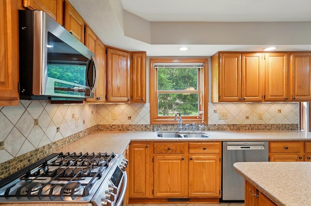 7227 Stemen Rd, Pickerington, OH 43147 - kitchen featuring stainless steel appliances, a sink, decorative backsplash, brown cabinetry, and light stone countertops