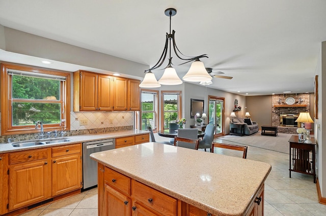 7227 Stemen Rd, Pickerington, OH 43147 - kitchen with dishwasher, a sink, light tile patterned flooring, tasteful backsplash, and a brick fireplace
