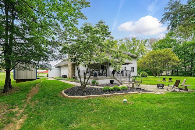 7227 Stemen Rd, Pickerington, OH 43147 - back of house featuring an outdoor fire pit, a porch, a lawn, central air condition unit, and a storage shed