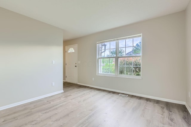 unfurnished room featuring baseboards and light wood-style flooring