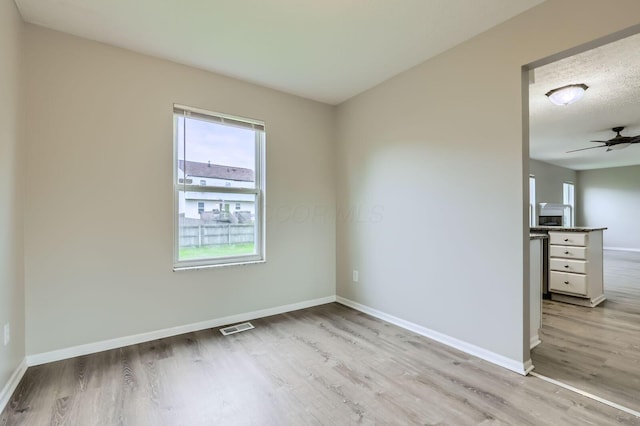 unfurnished bedroom with light wood-type flooring, multiple windows, and baseboards