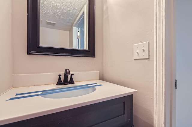 bathroom with vanity and a textured ceiling