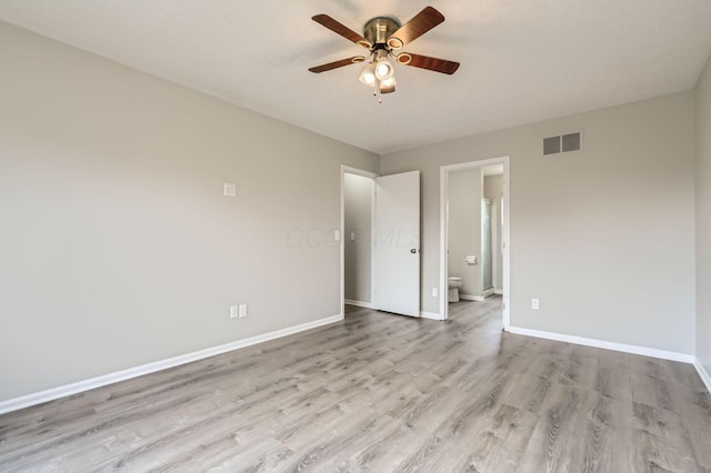 unfurnished bedroom with light wood finished floors, baseboards, connected bathroom, and a ceiling fan