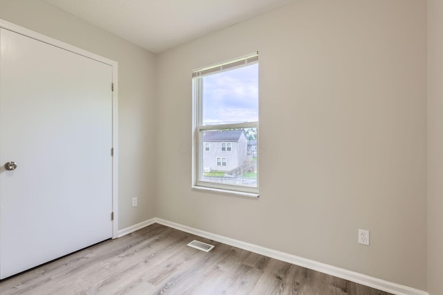 unfurnished room with light wood finished floors and baseboards