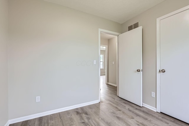unfurnished bedroom featuring light wood-type flooring and baseboards