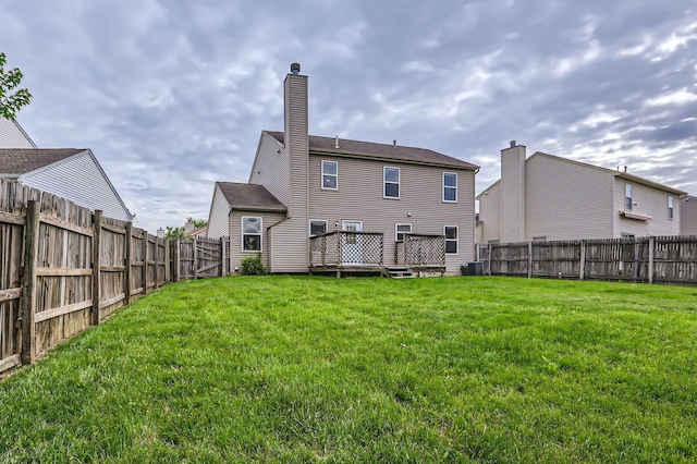 rear view of property with a wooden deck, cooling unit, and a chimney