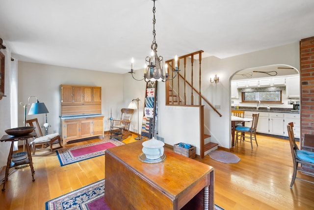 13535 Vans Valley Rd, Galena, OH 43021 - living room featuring light wood finished floors, stairway, a chandelier, and arched walkways