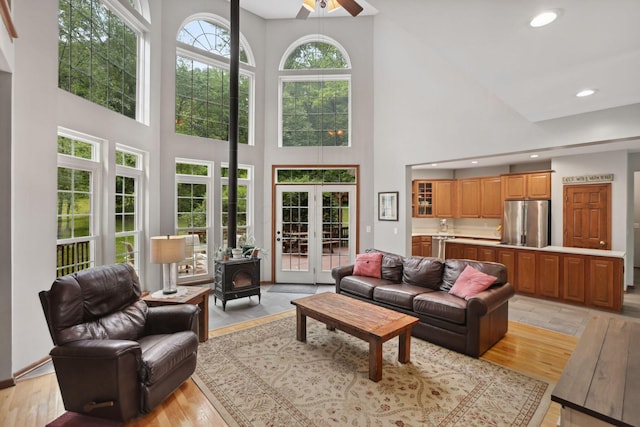 7235 Ballou Rd, Heath, OH 43056 - living area featuring a high ceiling, french doors, a wood stove, light wood-style floors, and a ceiling fan