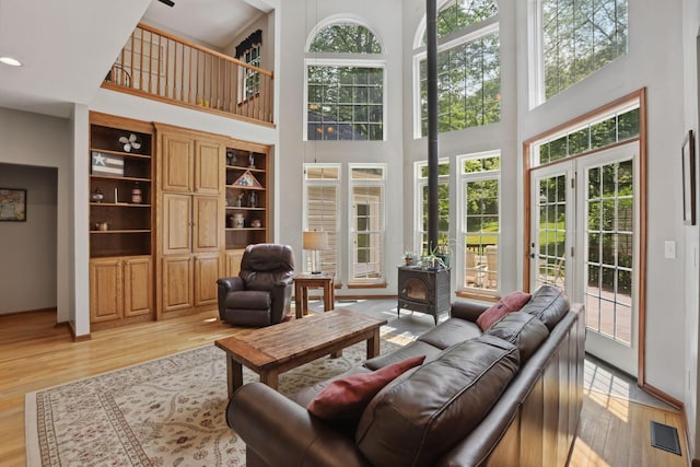 7235 Ballou Rd, Heath, OH 43056 - living room with a wood stove, light wood-style flooring, a towering ceiling, and french doors