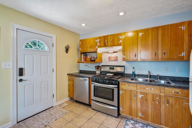 19 Vaughn Rd, Delaware, OH 43015 - kitchen featuring stainless steel appliances, under cabinet range hood, brown cabinets, dark countertops, and light tile patterned floors