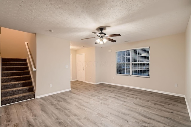 3983 Summerstone Dr, Columbus, OH 43230 - unfurnished living room with wood finished floors, a ceiling fan, stairway, a textured ceiling, and baseboards