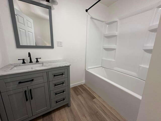19966 Happy Hollow Rd, Laurelville, OH 43135 - bathroom featuring wood finished floors, vanity, baseboards, and shower / tub combination