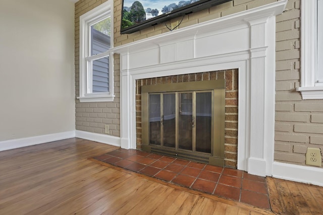 206 Goose Pond Rd, Newark, OH 43055 - detailed view of baseboards, a brick fireplace, wood finished floors, and brick wall