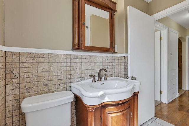 206 Goose Pond Rd, Newark, OH 43055 - bathroom with tile walls, vanity, a wainscoted wall, toilet, and wood finished floors