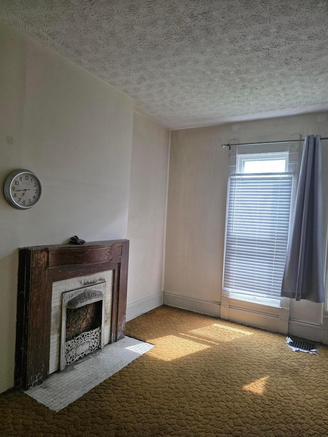 195 N Monroe Ave, Columbus, OH 43203 - unfurnished living room with carpet floors, a premium fireplace, a textured ceiling, and baseboards