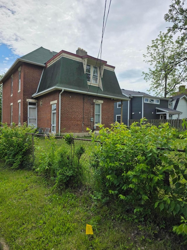 195 N Monroe Ave, Columbus, OH 43203 - back of house featuring brick siding, mansard roof, fence, and roof with shingles