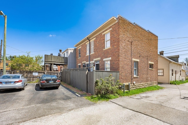 view of side of property with fence and brick siding