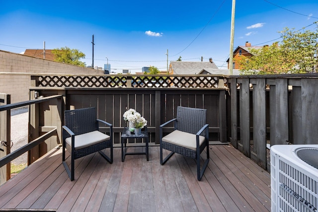 deck featuring central air condition unit and fence