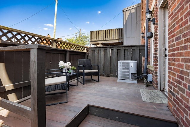 deck featuring cooling unit and fence