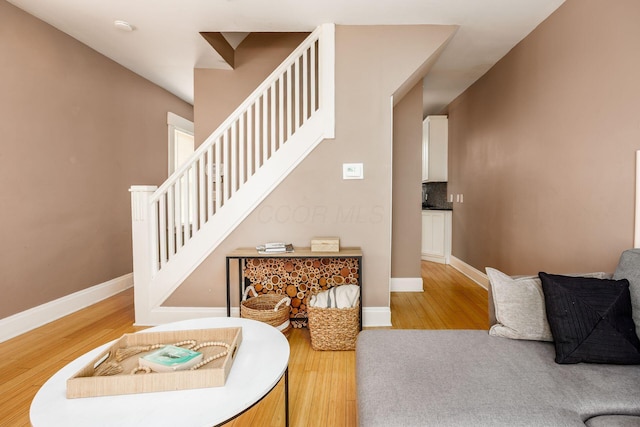 stairway featuring wood finished floors and baseboards