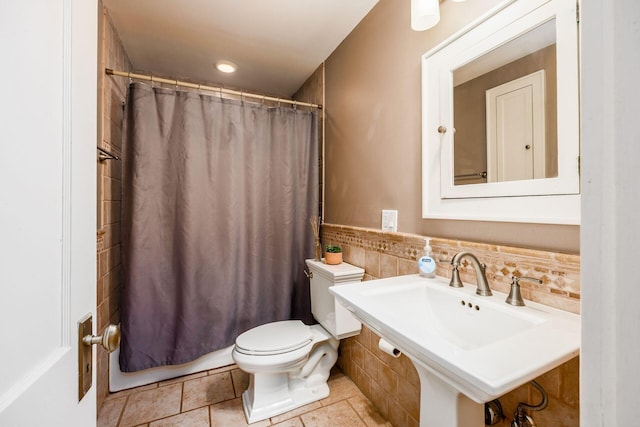 full bathroom featuring toilet, tile walls, and a sink