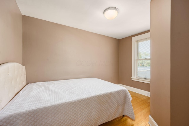 bedroom with light wood-type flooring and baseboards