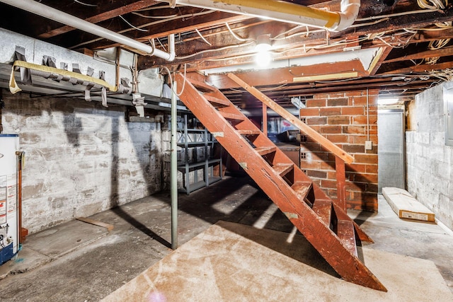 unfinished below grade area featuring stairs and gas water heater