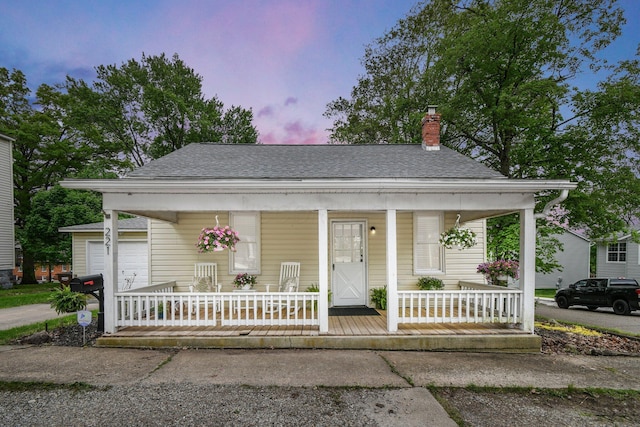 221 W Mulberry St, Baltimore, OH 43105 - bungalow with covered porch, roof with shingles, a chimney, and a garage