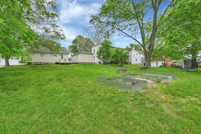 221 W Mulberry St, Baltimore, OH 43105 - view of grassy yard with a trampoline, a garden, an outbuilding, a deck, and a storage unit
