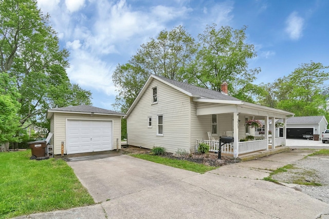 221 W Mulberry St, Baltimore, OH 43105 - view of property exterior with covered porch, an outdoor structure, a chimney, a detached garage, and concrete driveway