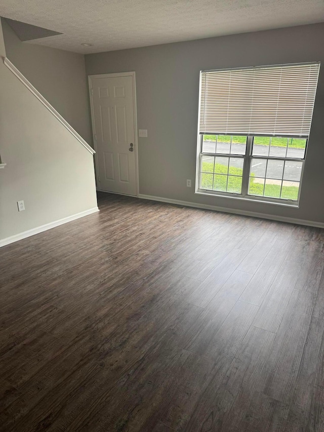 5076 Dalmeny Ct, Columbus, OH 43220 - unfurnished living room with dark wood finished floors, baseboards, and a textured ceiling