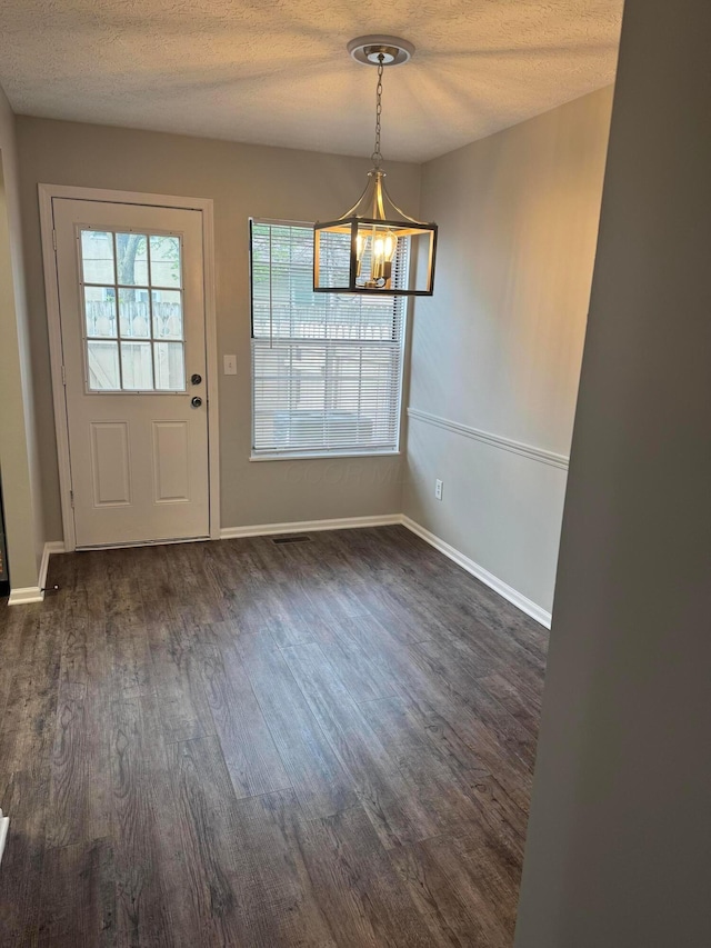 5076 Dalmeny Ct, Columbus, OH 43220 - unfurnished dining area featuring a chandelier, dark wood-type flooring, a textured ceiling, and baseboards