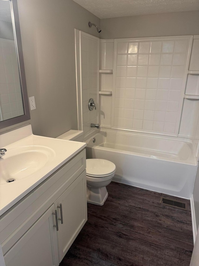5076 Dalmeny Ct, Columbus, OH 43220 - bathroom featuring wood finished floors, shower / bath combination, toilet, vanity, and a textured ceiling