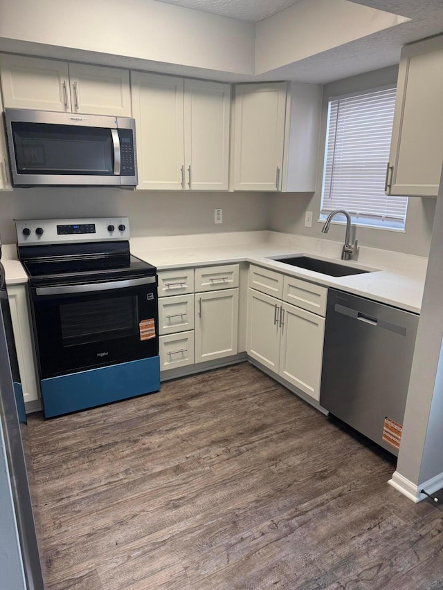 5076 Dalmeny Ct, Columbus, OH 43220 - kitchen with appliances with stainless steel finishes, a sink, light countertops, and dark wood-type flooring