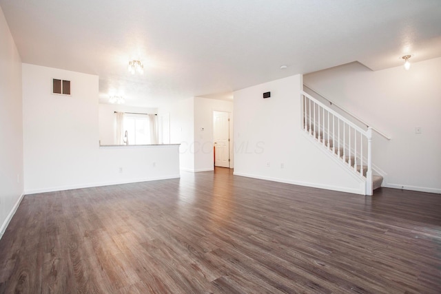 960 Hartford Village Blvd, Columbus, OH 43228 - unfurnished living room with stairs, dark wood-style flooring, and baseboards