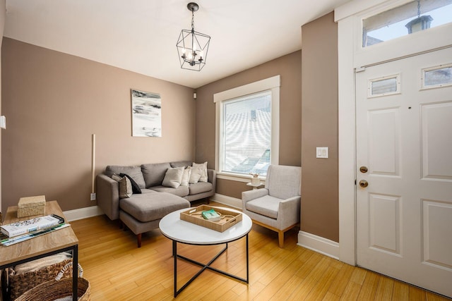 204-206 E Blenkner St, Columbus, OH 43206 - living room featuring baseboards, light wood-style flooring, and a chandelier