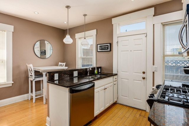 204-206 E Blenkner St, Columbus, OH 43206 - kitchen with dishwashing machine, a sink, light wood-style flooring, a peninsula, and white cabinets