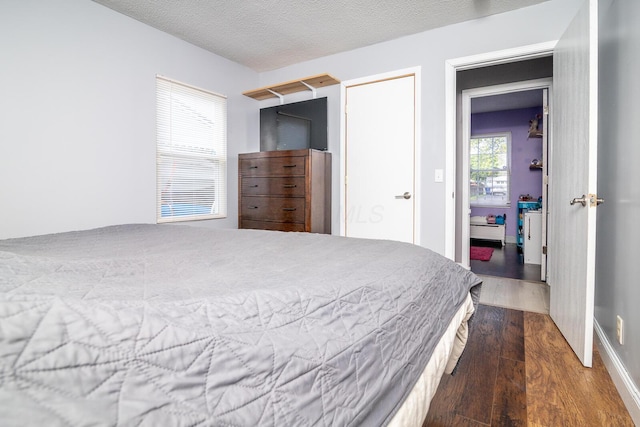 2806 Claude Dr, Columbus, OH 43207 - bedroom with wood finished floors, baseboard heating, and a textured ceiling