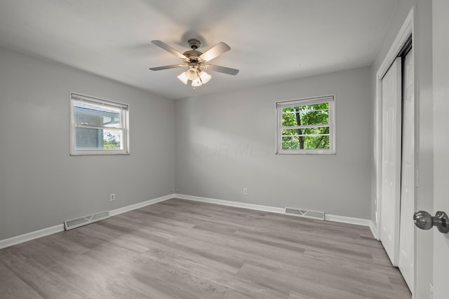 4187 Medway Ave, Columbus, OH 43213 - unfurnished bedroom featuring multiple windows, light wood-style floors, baseboards, and a closet