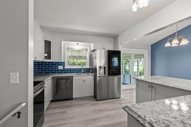 4187 Medway Ave, Columbus, OH 43213 - kitchen featuring appliances with stainless steel finishes, a sink, backsplash, healthy amount of natural light, and vaulted ceiling