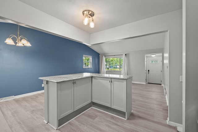 4187 Medway Ave, Columbus, OH 43213 - kitchen featuring lofted ceiling, baseboards, light wood finished floors, light stone counters, and a chandelier